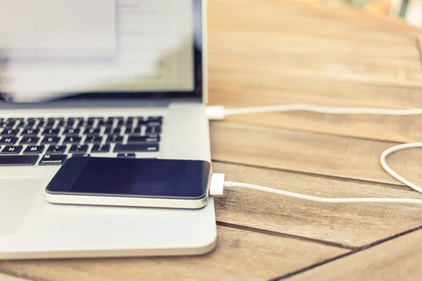 bir dizüstü bilgisayar tarafından tahsil ediliyor smartphone