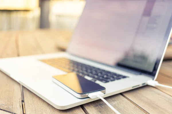 bir dizüstü bilgisayar tarafından tahsil ediliyor smartphone