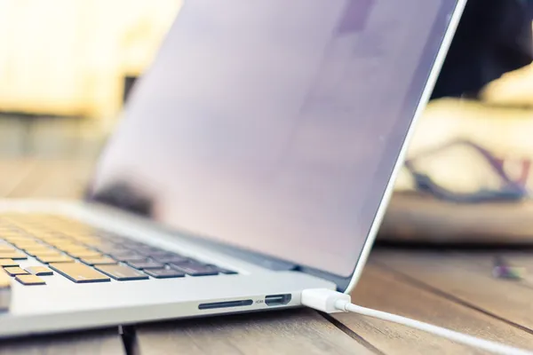 Smartphone being charged by a laptop — Stock Photo, Image