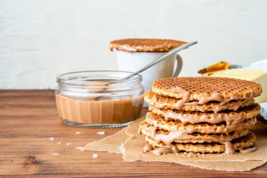 Geleneksel Hollanda usulü otantik Hollanda tatlı ev yapımı lezzetli kahverengi waffle erimiş tuzlu karamelli bal pekmezi ve Stroopwafel adında sıcak kahve sütlü çay.