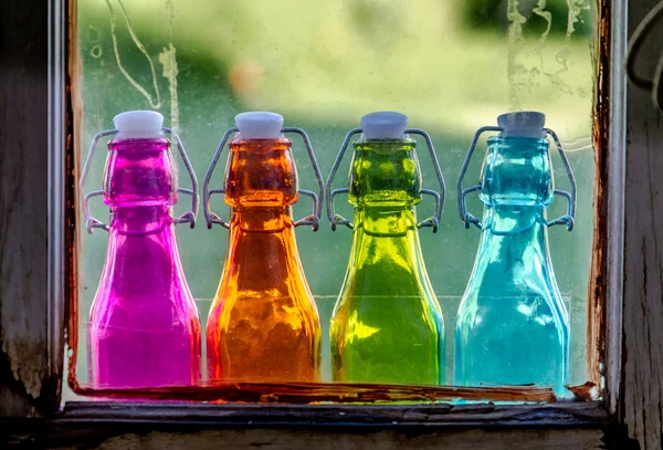 Färgade vintage flaskor på fönsterbrädan — Stockfoto