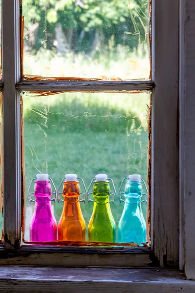 Garrafas vintage coloridas no preenchimento da janela — Fotografia de Stock
