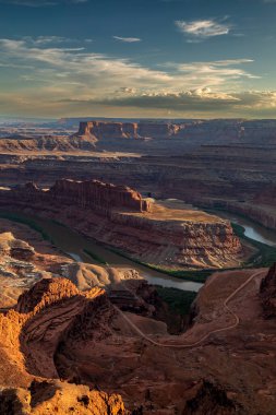 Günbatımında Colorado Nehri 'ne bakan Moab ve Canyonlands Ulusal Parkı yakınlarındaki Utah' taki Deadhorse Point 'in güney kenarındaki patikaya bakın.