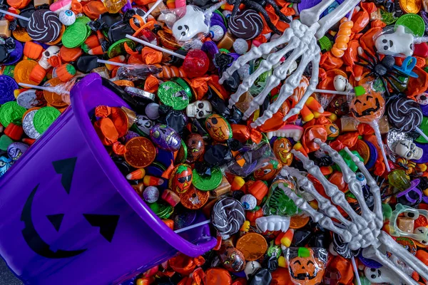 Skeleton Hands Grabbing Variety Halloween Candy Spilling Out Dark Purple — Stock Photo, Image