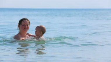 Anne ile bebeği denizde oyun