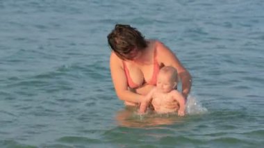 Anne ile bebeği denizde oyun