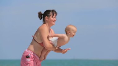 Anne oğlu ile kumsalda oynarken