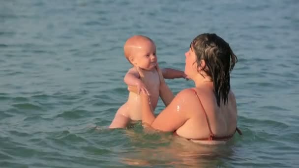 Madre con su bebé jugando en el mar — Vídeos de Stock