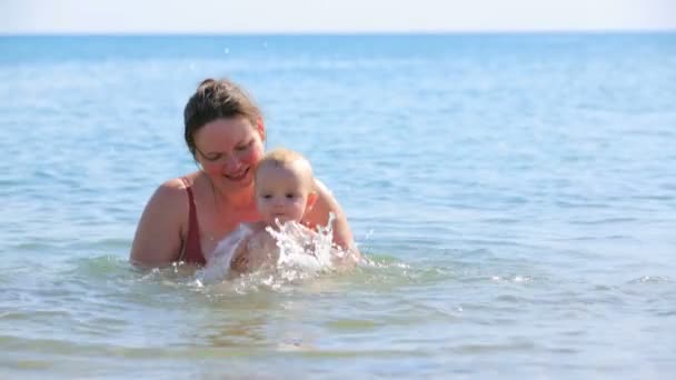 Mãe com seu bebê brincando no mar — Vídeo de Stock