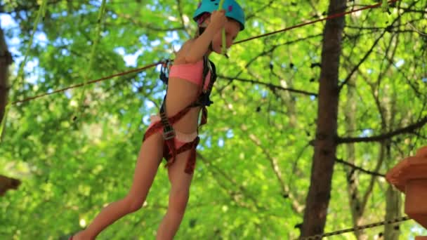 Маленька дівчинка в шоломі в мотузковому парку — стокове відео