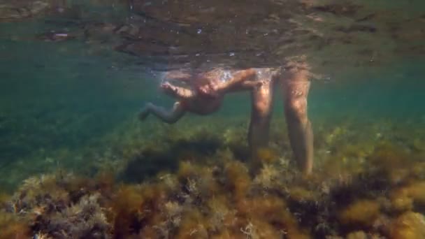 Мальчик с матерью плавают под водой — стоковое видео