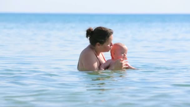 Madre con su bebé jugando en el mar — Vídeos de Stock