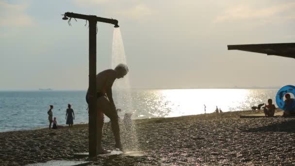 Νεαρός άνδρας λαμβάνοντας ντους στην παραλία — Αρχείο Βίντεο