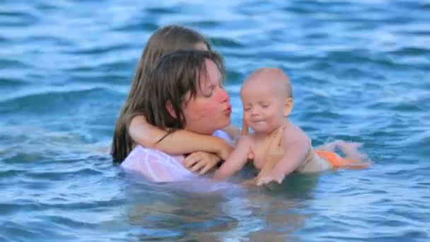 Mãe com seu bebê brincando no mar — Vídeo de Stock