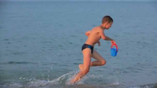 Menina e menino brincando no mar — Vídeo de Stock