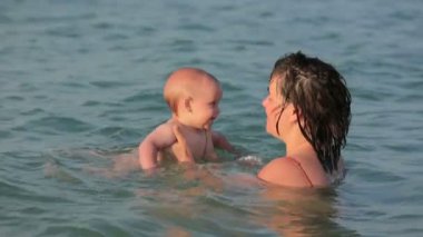 Anne ile bebeği denizde oyun