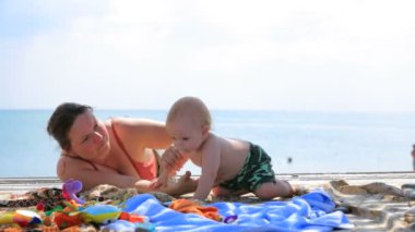 Anne oğlu ile kumsalda oynarken