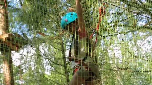 Petite fille en casque au parc de corde 
