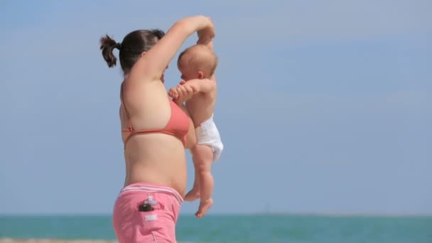 Moeder spelen met haar zoon op strand — Stockvideo