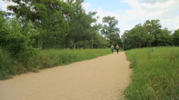 Dvě mladé dívky běhání v parku — Stock video