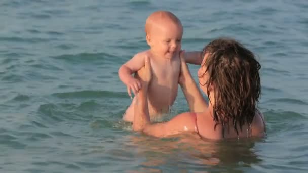 Mãe com seu bebê brincando no mar — Vídeo de Stock