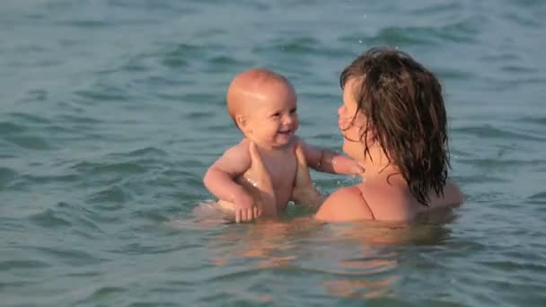 Mother with her baby playing in the sea — Stock Video