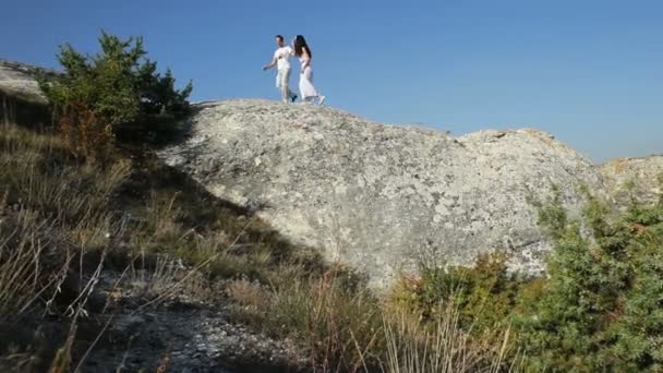 Ehepaar spaziert am Felsen entlang — Stockvideo