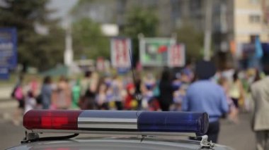Polis arabanın ışıkları yanıp sönen arka planda yak²n seyircilerle