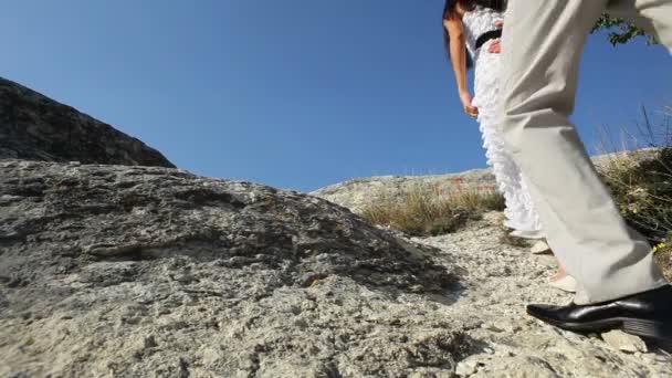 Молодожены гуляют по холму — стоковое видео