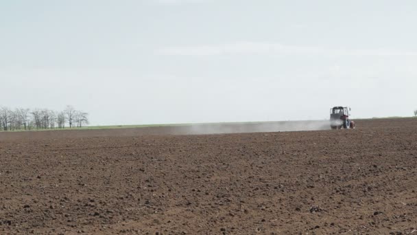 Boerderij trekker sproeien veld — Stockvideo