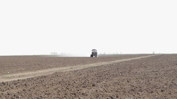 Boerderij trekker sproeien veld — Stockvideo