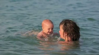 Anne ile bebeği denizde oyun