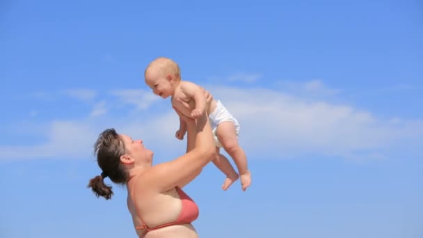 Mother playing with her son on beach — Stock Video