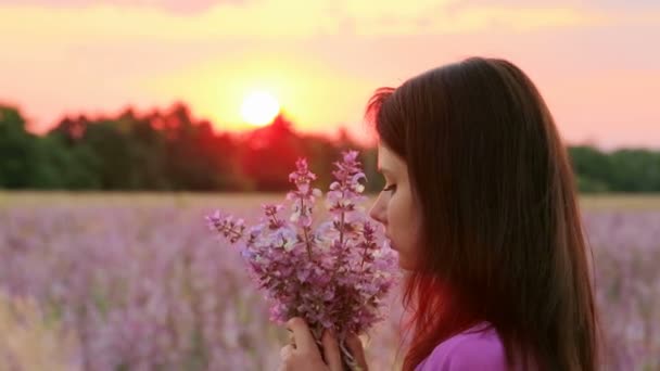 Young attractive woman in the flower meadow — Stock Video