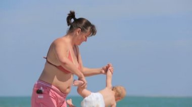 Anne oğlu ile kumsalda oynarken