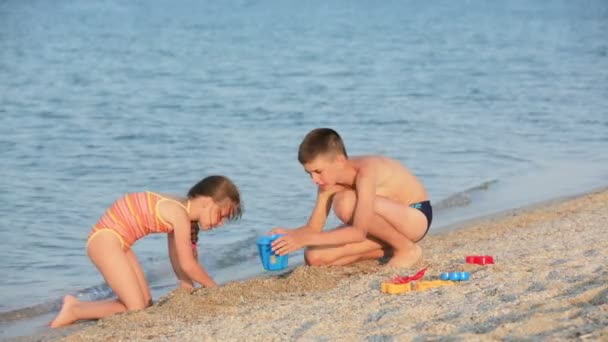 Niño y niña en la playa — Vídeos de Stock