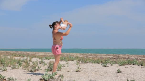 Mutter spielt mit ihrem Sohn am Strand — Stockvideo