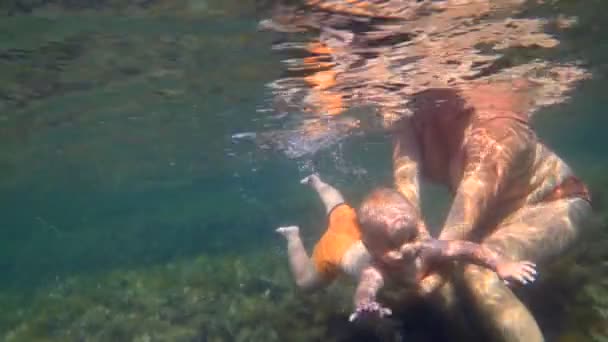 Bébé garçon avec sa mère nageant sous l'eau — Video