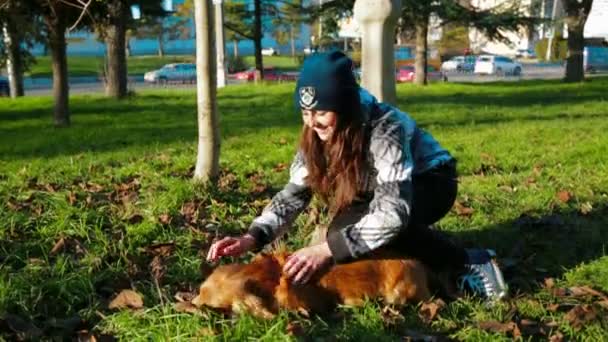 Menina jovem acariciando seu cão ao ar livre — Vídeo de Stock