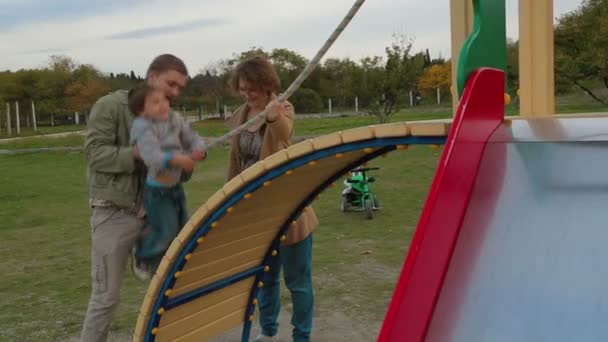 Lycklig familj av tre på lekplats. — Stockvideo