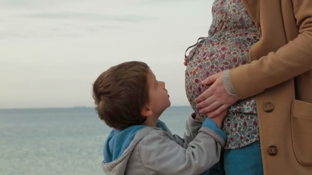 Lille son allomfattande sin gravid mamma. — Stockvideo