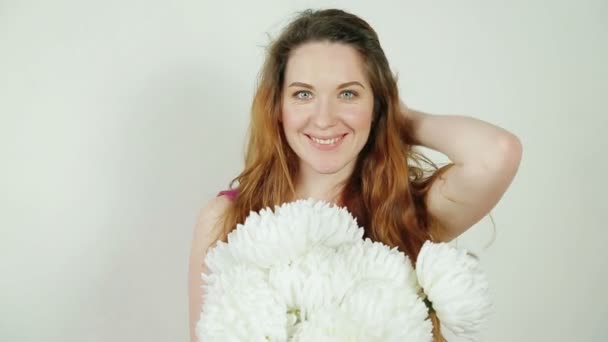 Mujer joven sosteniendo flores blancas — Vídeos de Stock