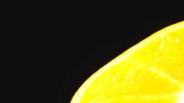 4K Macro portakal meyvesi ve dönüş. Siyah arka planda izole edilmiş taze turunçgil portakalını kapat.