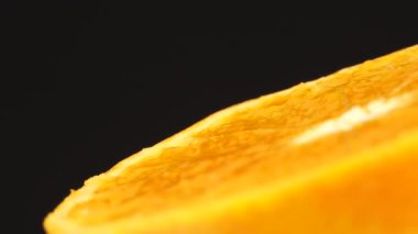 4K Macro portakal meyvesi ve dönüş. Siyah arka planda izole edilmiş taze turunçgil portakalını kapat.