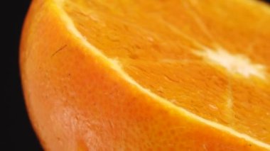 4K Macro portakal meyvesi ve dönüş. Siyah arka planda izole edilmiş taze turunçgil portakalını kapat.