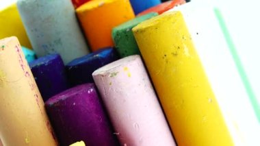 4K yakın plan renkli pastel boya kalemleri siyah arkaplanda izole edilmiş dönen plaka üzerinde çizim yapmak için