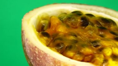 Gözbebeği tutkusunun 4K enine kesiti. Dilimlenmiş taze egzotik çarkıfelek meyvesi Macro shot 'ı. CG yeşil arka planda izole edilmiş.