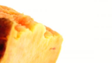  4K Macro turuncu tatlı patates dilimlerini turntable 'da döndürüyor. Beyaz arka planda izole edilmiş. Yakın plan. Makro.