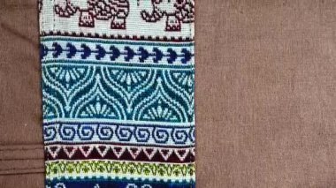 4K. 60 yıldan daha eski renkli Tayland el sanatları Peru tarzı halı yüzeyi. Doğal malzemelerden yapılmış eski, yırtık, antika bir muhafaza.