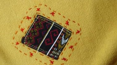 4K. 60 yıldan daha eski renkli Tayland pamuk el işi Peru tarzı halı yüzeyi. Doğal malzemelerden yapılmış eski, yırtık, antika bir muhafaza.